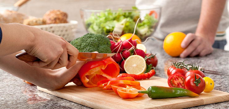 Cutting a vegetables for a salad with an olive oil