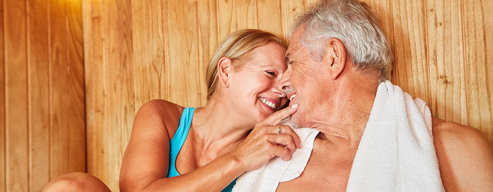 Verliebtes Senioren Paar sitzt zusammen in der Sauna im Wellness Hotel