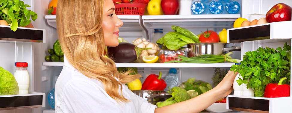 Woman-Filling-Fridge-with-Healthy-Food-for-Post-Holiday-Detox