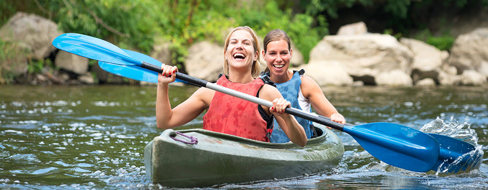 Friends Kayaking in Spring to Workout in Nature